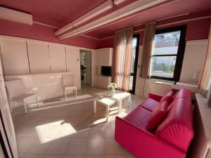 里乔内Villetta Trieste-Flexrent Abissinia的客厅配有红色的沙发和桌子