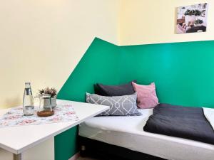 HerzbergPension am Plan的一间设有绿色墙壁和一张床的客房