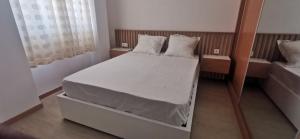 普拉亚Ondas Relax House的一间卧室配有带白色床单和枕头的床。