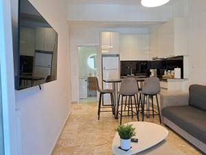 帕特雷Luxury Suite Patras (2)的客厅以及带沙发和桌子的厨房。