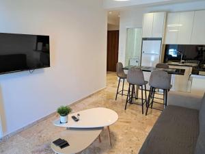 帕特雷Luxury Suite Patras (2)的客厅配有电视和桌椅