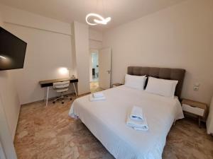 帕特雷Luxury Suite Patras (2)的卧室配有一张白色大床和一张书桌