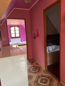 布达佩斯BRC Hostel & Car Rent Budapest的浴室设有粉红色的墙壁、浴缸和镜子