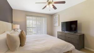 休斯顿Landing - Modern Apartment with Amazing Amenities (ID9254X75)的一间卧室配有一张带吊扇的床和一台电视。