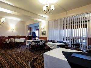 牛顿阿伯特The Keyberry Hotel的餐厅内带桌椅的用餐室
