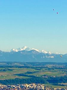 GrandeventTévenon Vue Panoramique Alpes-Lac的两个热气球飞越一个雪覆盖的城市