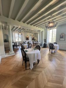 BonnevalHôtel du Château du Bois-Guibert的一间带桌椅和吊灯的用餐室