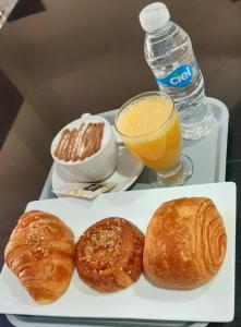 阿加迪尔Hôtel Riad Salam Agadir的盘子上放着一盘糕点和一杯橙汁