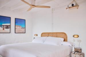 拉伊斯莱塔德尔摩洛Cortijo La Loma的卧室配有一张白色床,墙上挂有两张照片