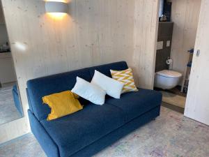 AeschiAuf Wolke 7 - Gäste-Studio im Mini House的一张蓝色的沙发,上面有四个枕头