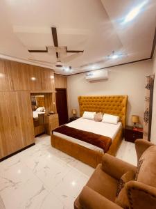 伊斯兰堡Britannia House near Islamabad International Airport and Motorway的一间卧室配有一张大床和一张沙发
