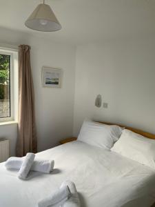 卡比斯贝St Merryn的卧室配有白色床和毛巾