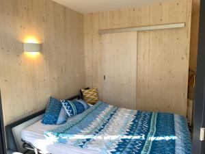 AeschiAuf Wolke 7 - Gäste-Studio im Mini House的一间卧室配有蓝色和白色床单
