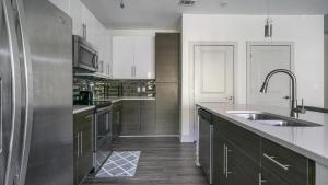 里士满Landing - Modern Apartment with Amazing Amenities (ID6167X30)的厨房配有水槽和不锈钢冰箱