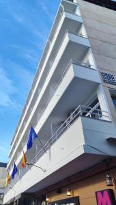 多列毛利诺斯Nch Hotel Torremolinos的一面有旗帜的白色建筑
