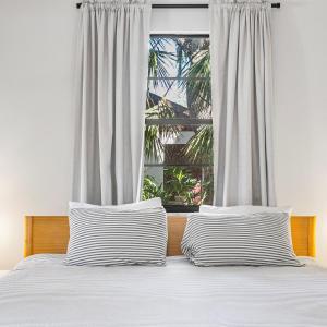 萨拉索塔Modern Vacation home near Siesta Key & Downtown的窗前带两个条纹枕头的床