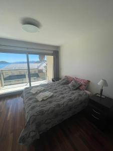 圣卡洛斯-德巴里洛切Duplex Quinta Luna的一间卧室设有一张床和一个大窗户
