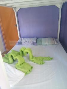 纳苏格布Purple Guesthouse的一张带绿毛巾的床