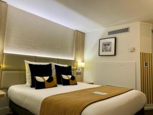 博讷博纳基里亚德酒店的酒店客房配有一张大床,提供黄色和黑色枕头