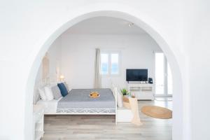 图罗斯With-inn Mykonos Suites的一间白色的卧室,配有床和客厅