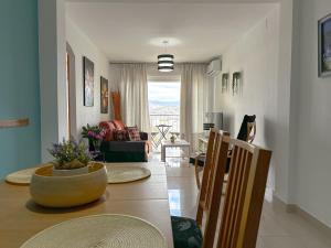 马拉加Apartamento Mirador del Mediterráneo的用餐室以及带桌椅的起居室。