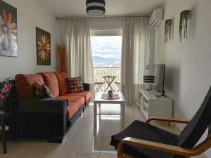 马拉加Apartamento Mirador del Mediterráneo的带沙发、桌子和窗户的客厅