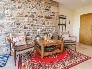 克利夫罗Hill Brook Barn的客厅配有桌椅和石墙