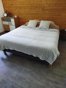 CarrougesLe cheval blanc的一间卧室设有一张带木墙的大床