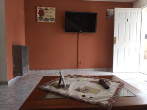 里奥加耶戈斯Lo de fernando 1的一间设有桌子的客房,墙上配有电视