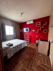 菲格雷多总统镇Amazon Home的一间卧室设有一张床和红色的墙壁
