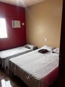 菲格雷多总统镇Amazon Home的红色墙壁客房的两张床
