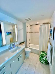 檀香山Luxury Oasis Residence的浴室配有盥洗盆、卫生间和浴缸。