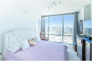 檀香山Luxury Oasis Residence的一间卧室设有一张大床和一个大窗户