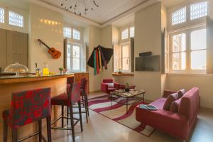 科英布拉Serenata Hotel & Hostel Coimbra的客厅设有酒吧和红色椅子