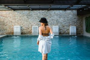 格拉玛多Bella Gramado Resort & Spa by Gramado Parks的站在游泳池旁的水面上的女人