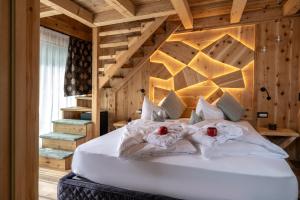 圣维吉利奥阿尔卑斯阿德勒公寓式酒店的卧室配有一张白色大床和木墙