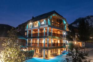 圣维吉利奥阿尔卑斯阿德勒公寓式酒店的一座在晚上有灯的大建筑