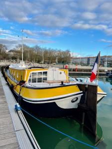 拉罗谢尔UNE PENICHE DANS LE BASSIN À FLOT DU VIEUX PORT的停靠在码头的黄色和白色船只