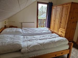 基希海姆Ferienhaus im Seepark von Kirchheim的一间卧室设有一张床和一个大窗户