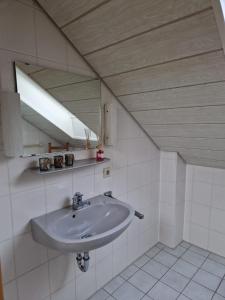 基希海姆Ferienhaus im Seepark von Kirchheim的一间带水槽和镜子的浴室