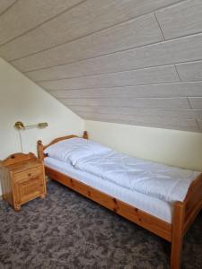 基希海姆Ferienhaus im Seepark von Kirchheim的一间卧室配有一张床和一个床头柜