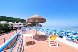 佩斯基奇Gemini Luxury Rooms的一个带椅子和遮阳伞的游泳池以及大海