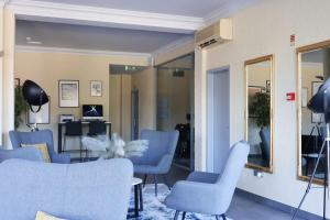 特罗法HOTEL SANTHYAGO TROFA的一间设有蓝色椅子和镜子的等候室