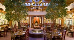 圣达菲拉方达广场酒店的一间带桌椅的餐厅和一个喷泉