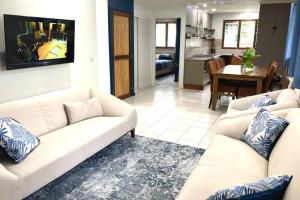 维拉港瓦努阿图海滨公寓酒店的一间带2张白色沙发的客厅和一间厨房
