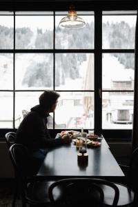 英格堡英格堡滑雪酒店的坐在窗前桌子上的人