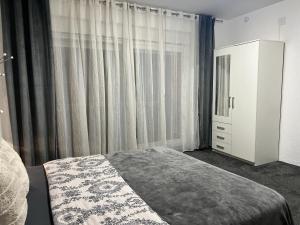 别洛瓦尔LuxRooms BJELOVAR的一间卧室配有床、梳妆台和窗帘