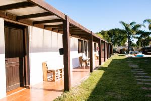 埃斯特角城La Quinta Hostel & Suites的一个带木制凉棚的房屋门廊