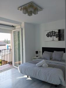 格拉纳达El Diez de Sultana的一间白色卧室,配有床和阳台
