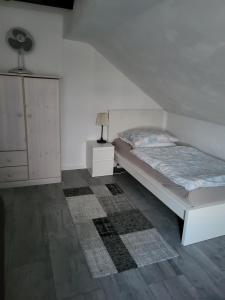 赫费尔霍夫Ferienwohnung的一间白色卧室,配有一张床和一个梳妆台